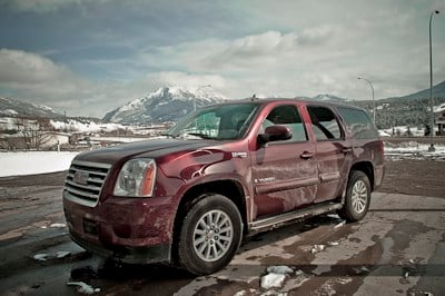 2009 GMC Yukon Hybrid front view in red parked outside in the mountains