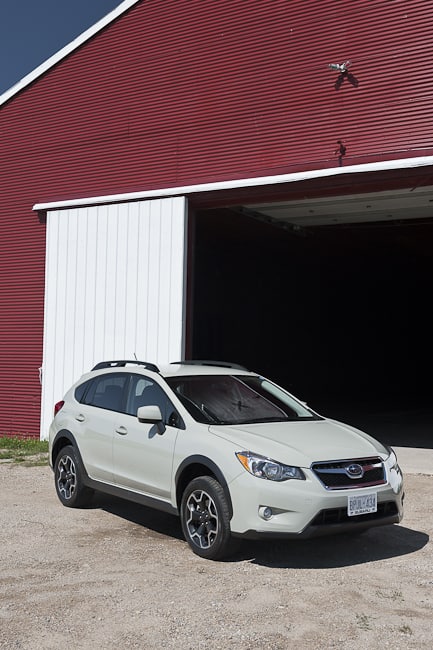 2013 Subaru XV Crosstrek parked in front of red barn