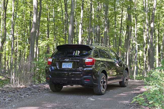 2013 Subaru XV Crosstrek black model driving through forest