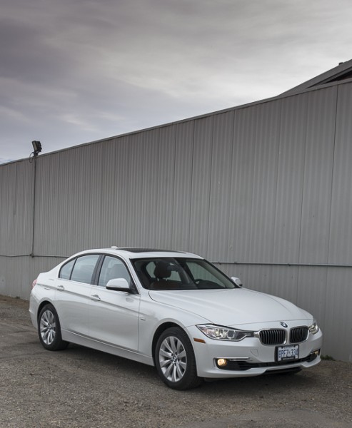 white 2013 BMW 328i xDrive front view parked by grey wall