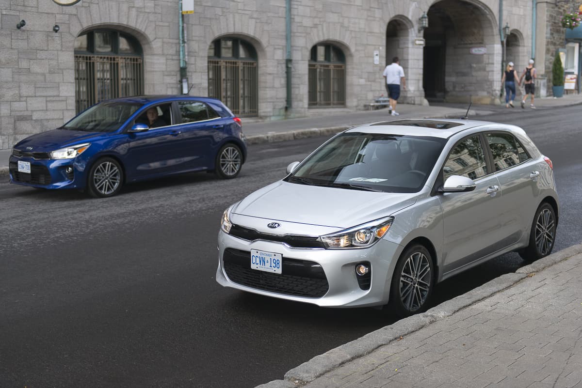 blue and silver 2018 Kia Rio Hatchback models on the street