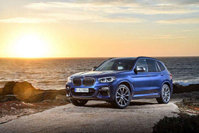 2018 BMW X3 in blue parked by ocean at sunset