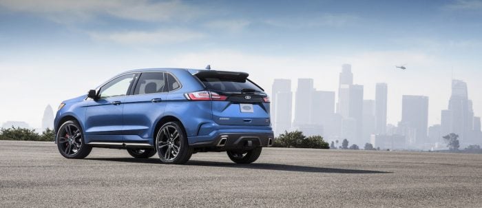 2019 Ford Edge ST rear view parked on street with city in the back