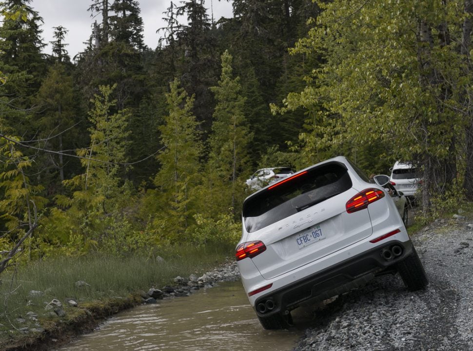 Porsche Travel Experience British Columbia Canada Cayenne SUVs driving through the water in the forest