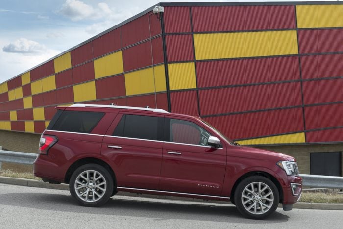 red 2019 Ford Expedition Platinum side view in front of colourful building