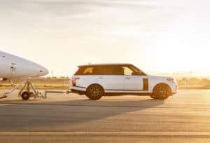 white Range Rover Astronaut Edition pulling a Virgin airplane on tarmac