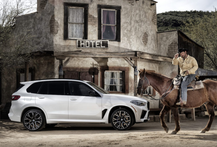 2020 BMW X5 M in front of a saloon with cowboy on horse