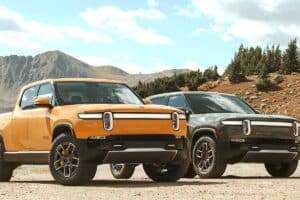 yellow and dark grey Rivian R1T trucks side by side