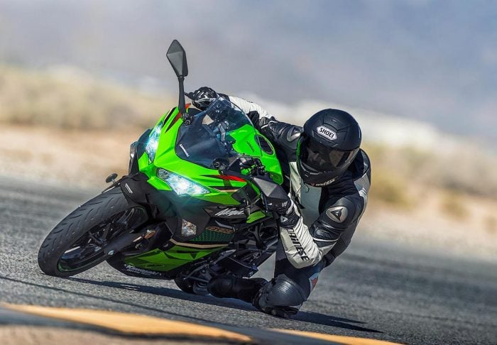 black and green Kawasaki Ninja 400 on the track with rider