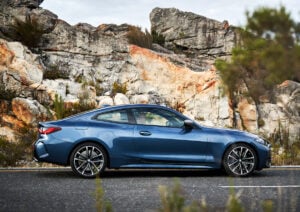 2021 bmw 4 series coupe in blue parked on street in front of jagged rocks