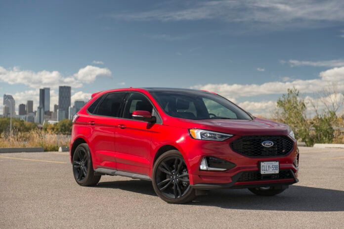 2020 Ford Edge ST front view in red with city in the back