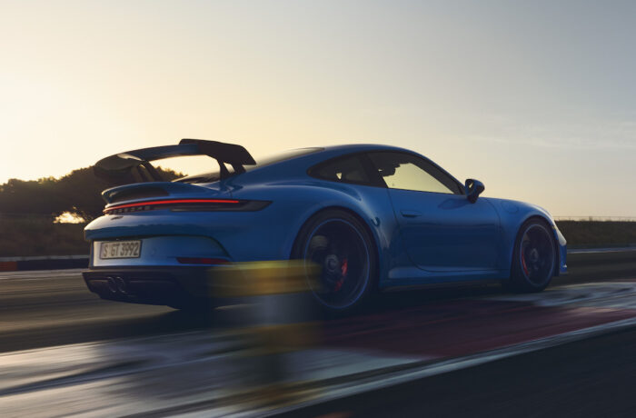 2022 Porsche 911 GT3 rear shot driving on track at sunset