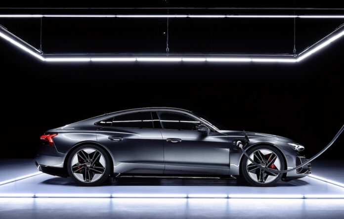 2022 Audi e-tron GT side view parked in studio being charged up