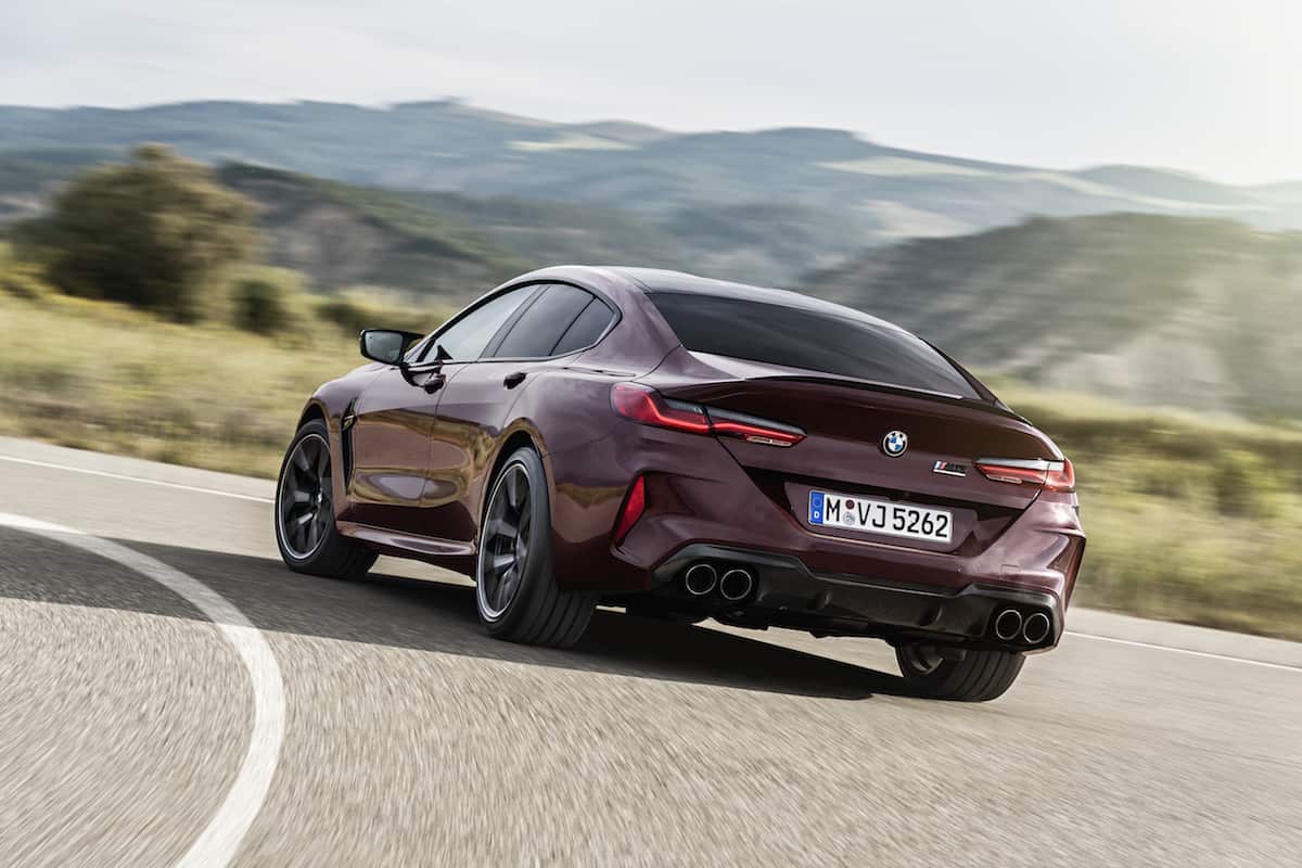 2021 BMW M8 Gran Coupe Competition rear driving around corner on road