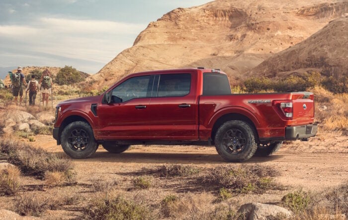 red Ford F-150 Rattler rear side view parked in off road setting