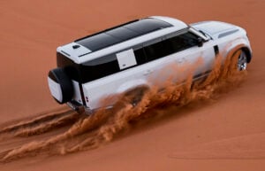 2023 Land Rover Defender 130 kicking up sand in the desert