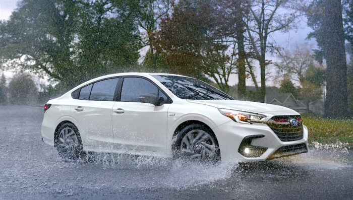 white 2023 Subaru Legacy Sport splashing through the water on the road