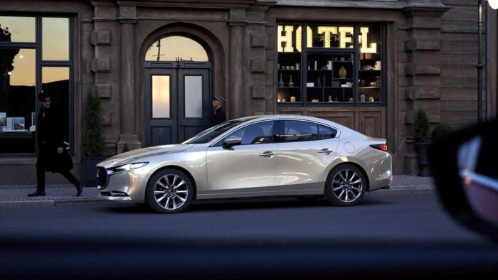 2026 Mazda3 side view parked on road by hotel lobby