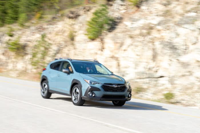 2024 Subaru Crosstrek in blue driving on the road