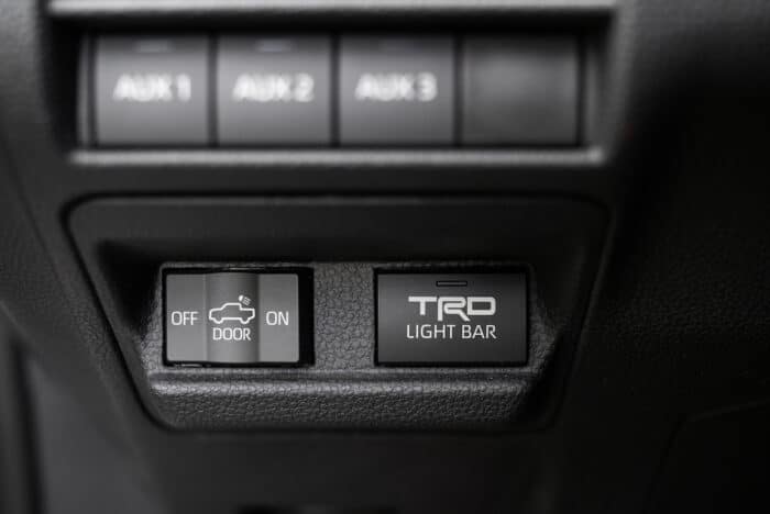 Three auxiliary toggle switches on the dashboard of 2024 Tacoma truck.