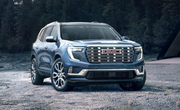 2024 GMC Acadia Denali front view parked on dirt in forest setting