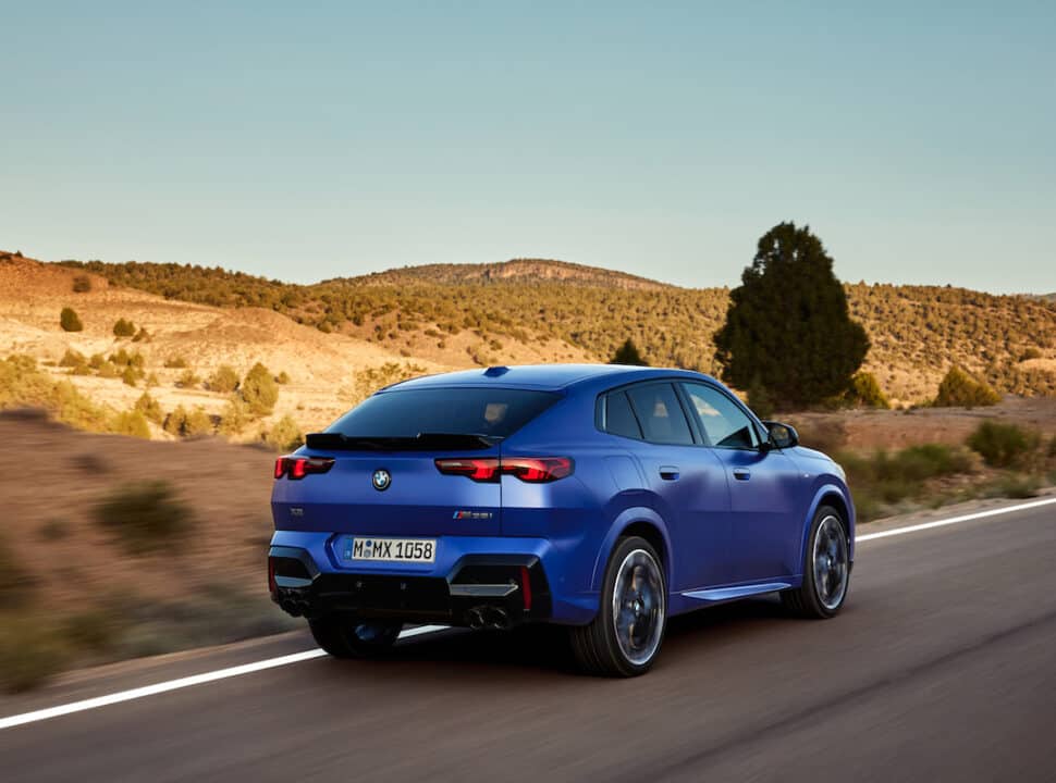 2024 BMW X2 M35i xDrive in blue driving on the road rear view