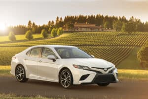 2018 Toyota Camry Hybrid SE front view parked by vineyard at sunset