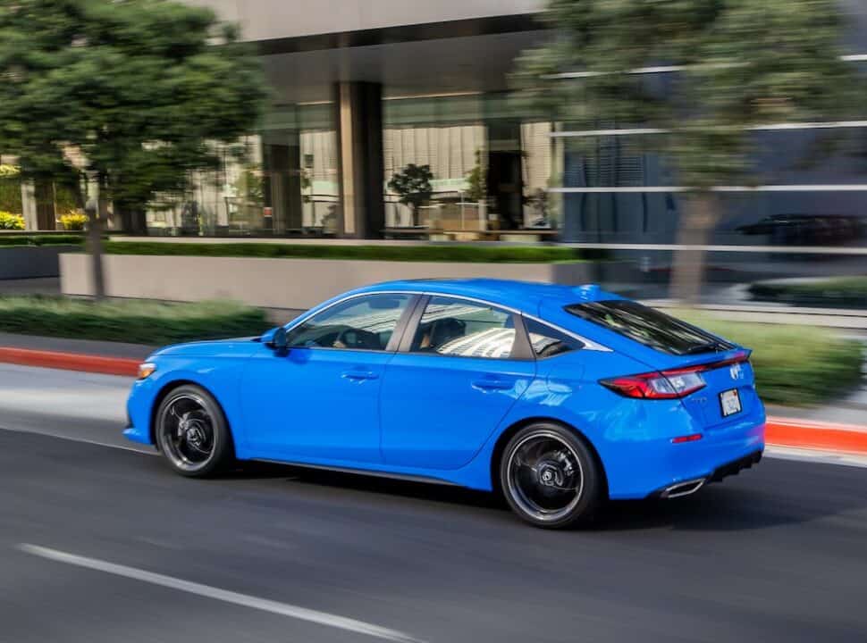 2022 Honda Civic Hatchback Sport Touring side view driving fast in urban setting