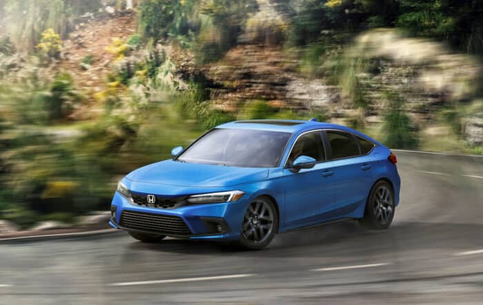 2022 Honda Civic Hatchback Sport Touring driving around a corner at high speeds