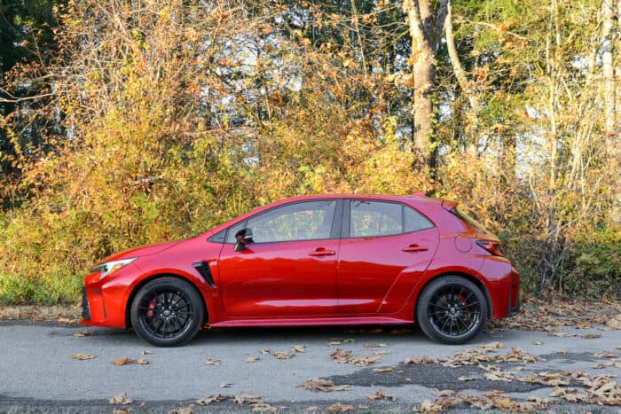 2023 Toyota GR Corolla Core sideview profile against fall leaves on quiet road