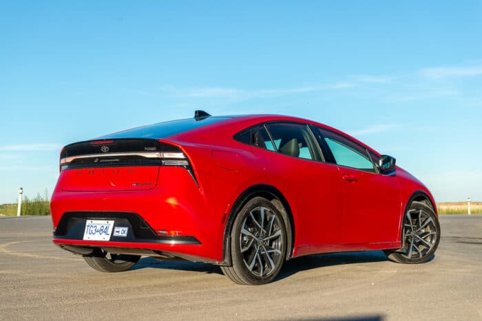 2024 Toyota Prius Prime XSE in red rear view profile parked on road