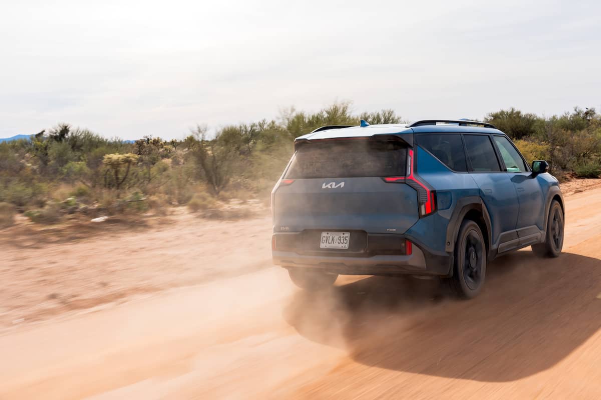 2024 Kia EV9 GT-Line driving fast on the dirt rear view