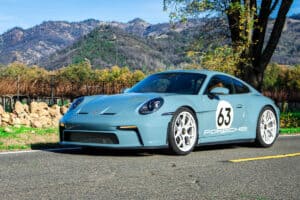 2024 Porsche 911 S/T front view parked on side of road by vineyard and rolling hills