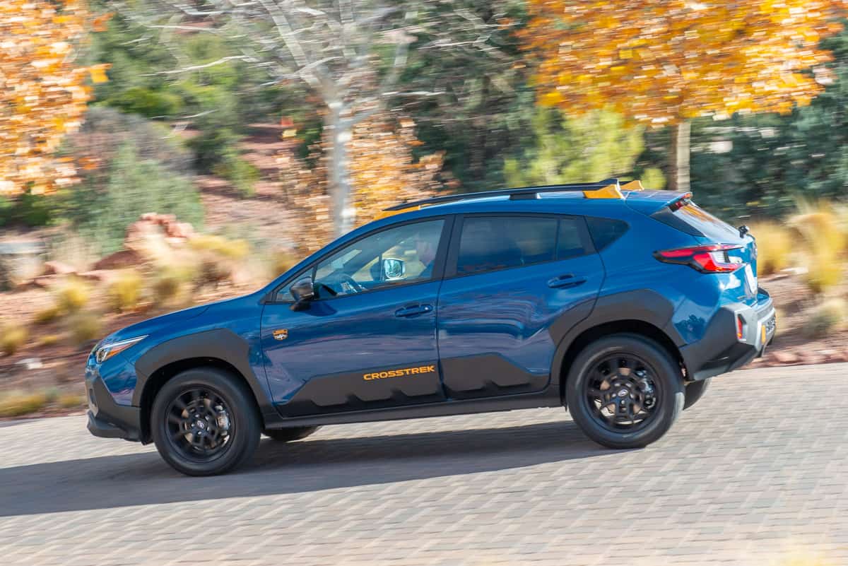 2024 Subaru Crosstrek Wilderness blue model driving down a road