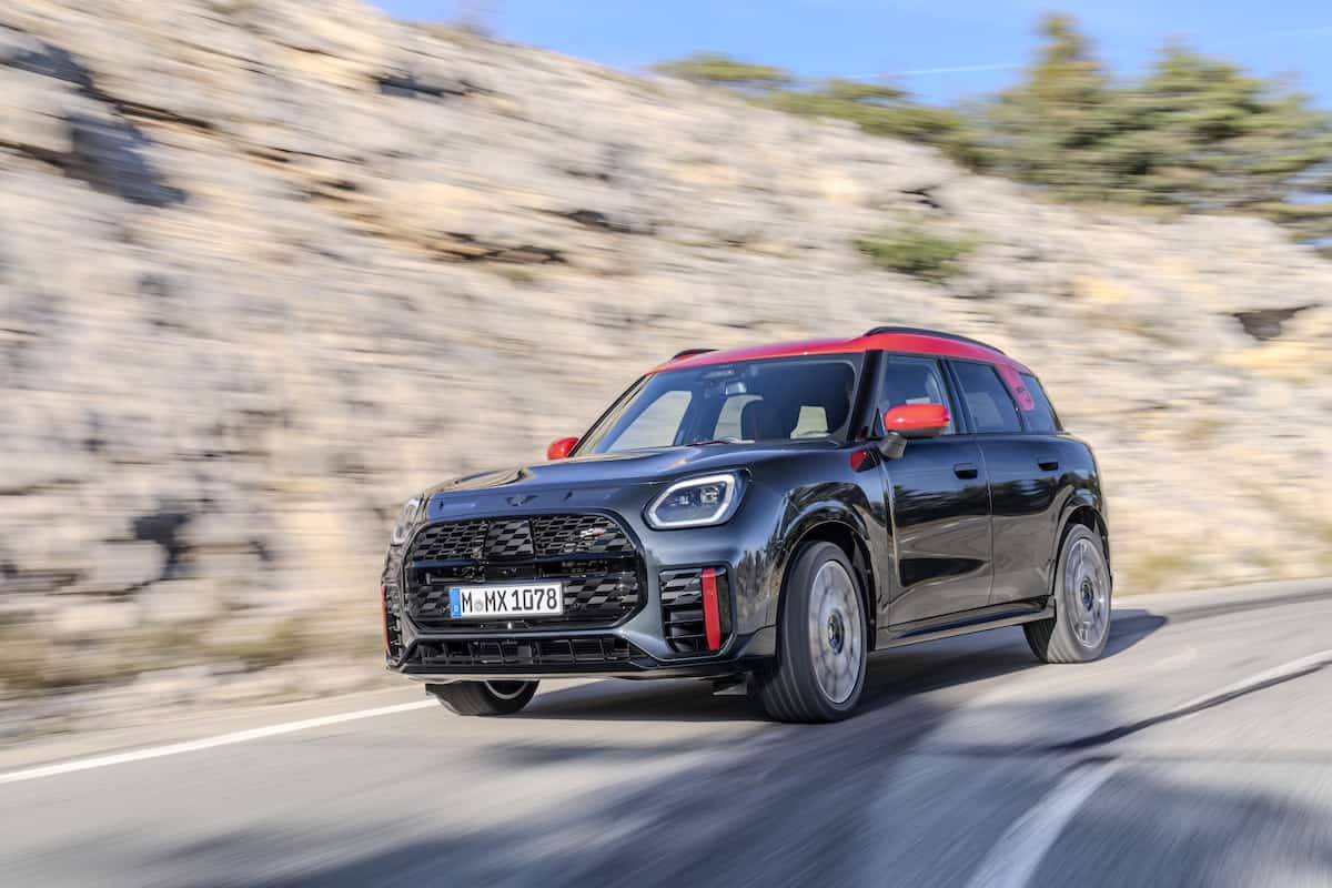 black and red 2025 MINI John Cooper Works Countryman driving around the bend, front view