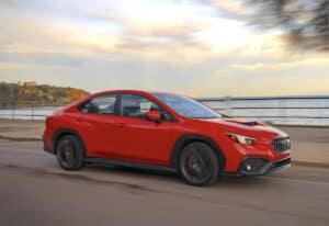 red 2024 SUBARU WRX TR driving along the ocean
