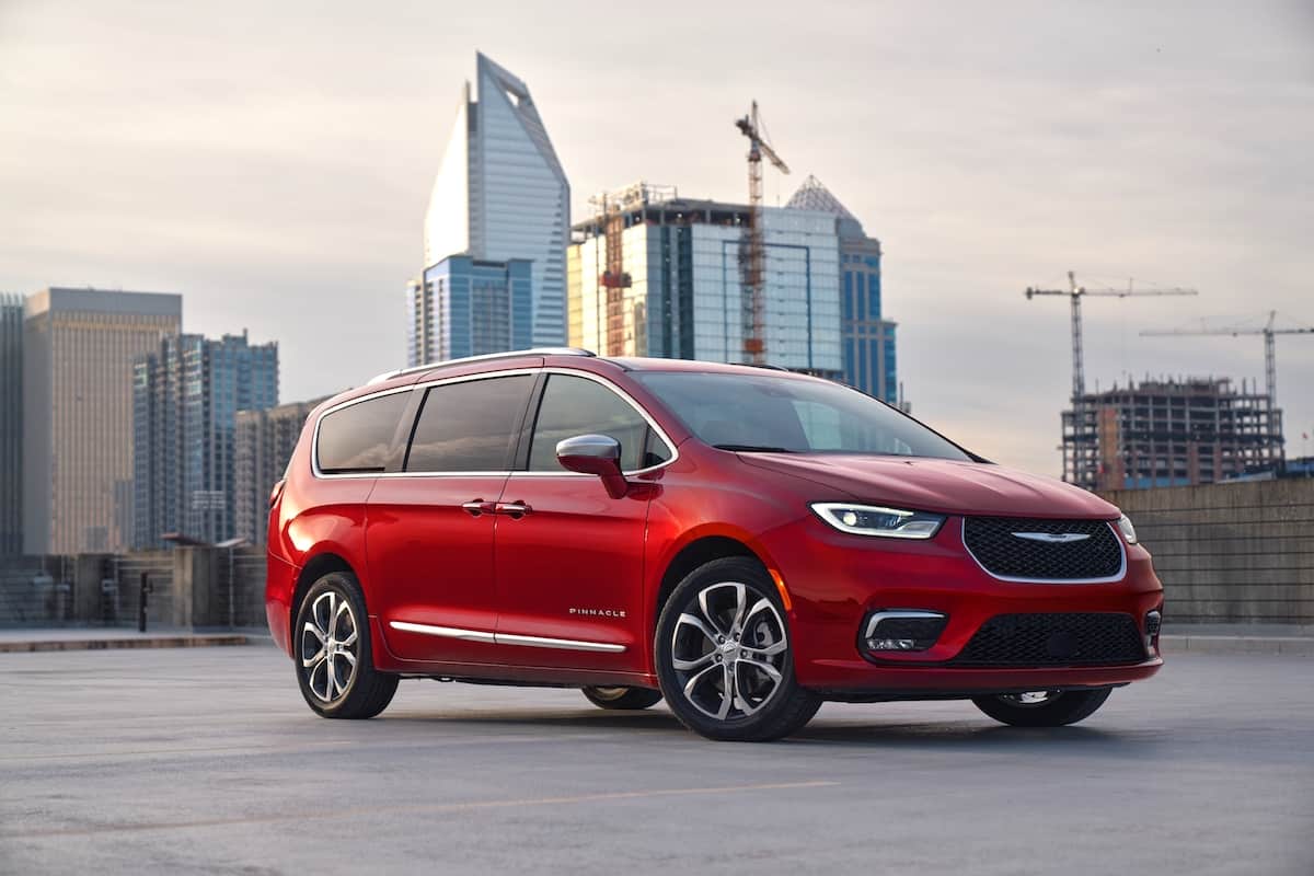 red 2024 Chrysler Pacifica Pinnacle front view parked outside with buildings in the back