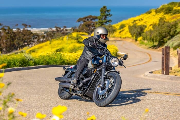 black, grey, and orange 2024 Honda Shadow Phantom on the road with rider