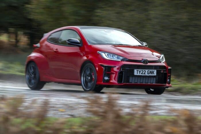 red Toyota GR Yaris front view driving fast on the road