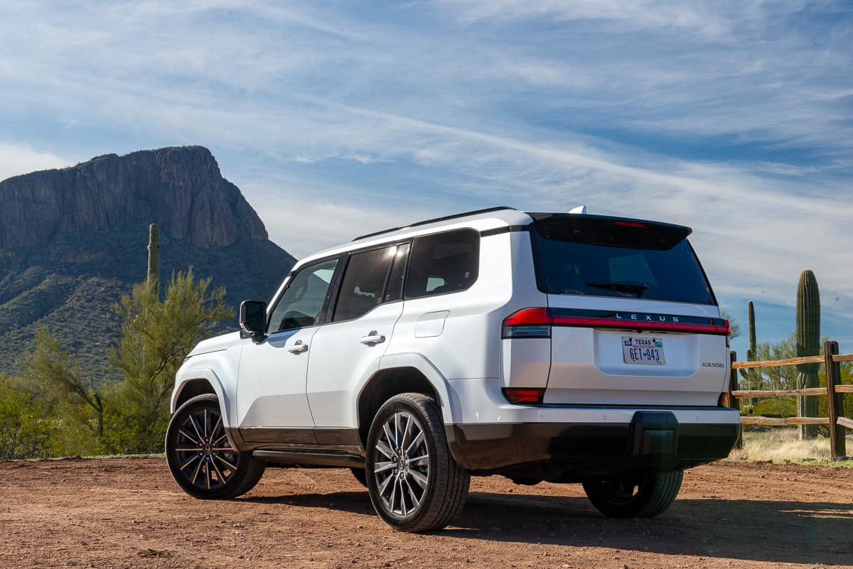 White 2024 Lexus GX 550 Luxury+ AWD rear view parked at a ranch