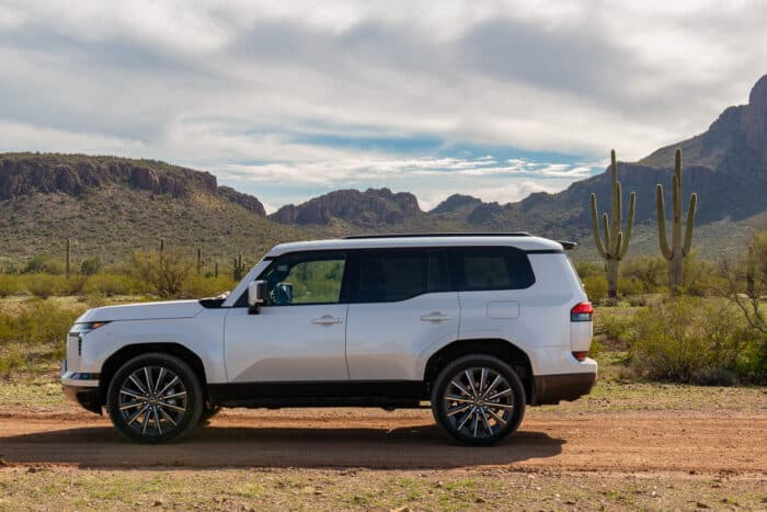 White 2024 Lexus GX 550 Luxury+ AWD side view parked on dirt road in desert