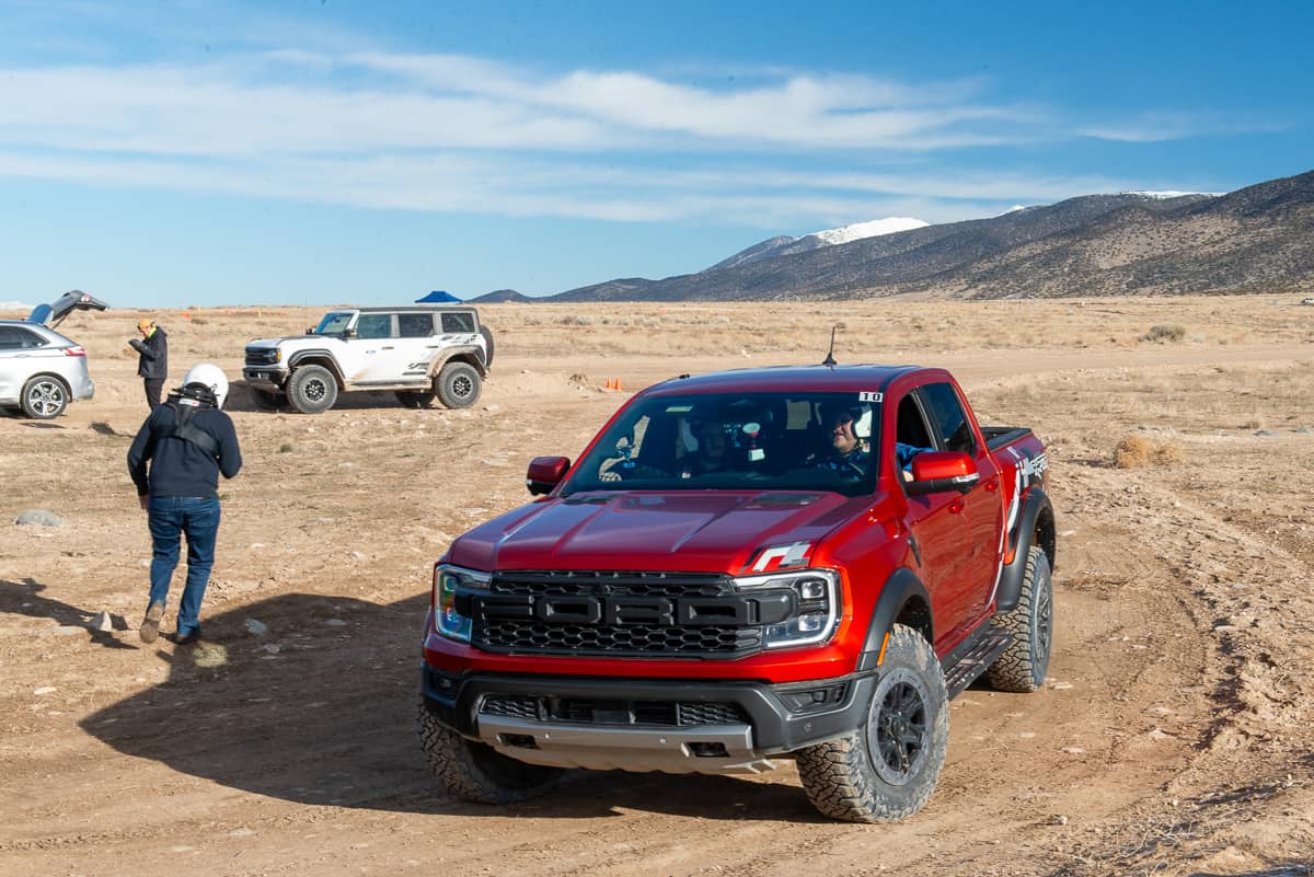 Front view driving shot of the 2024 Ford Ranger Raptor and white Bronco Raptor at the Ranger Raptor Assault School in Tooele Valley, Utah