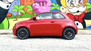 2024 Fiat 500e RED sideview in front of colourful wall
