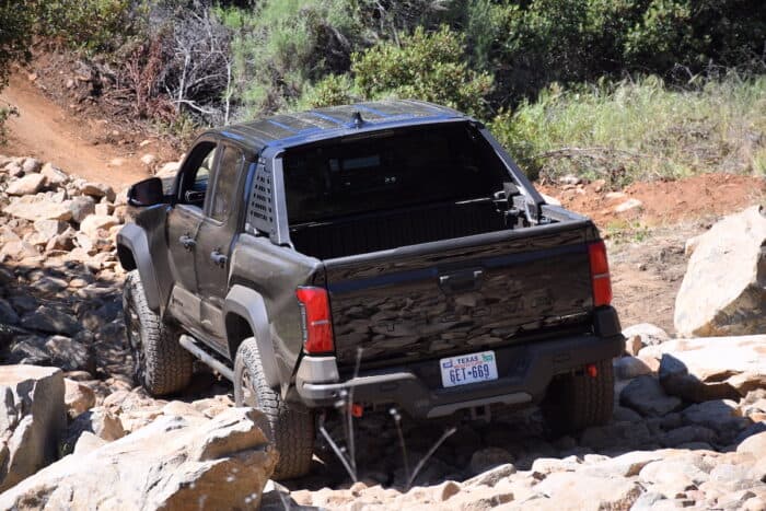 2024 Toyota Tacoma Hybrid i-Force-Max rear off roading over rocks