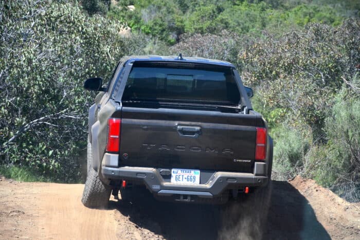 2024 Toyota Tacoma Hybrid i-Force-Max rear driving up dirt road