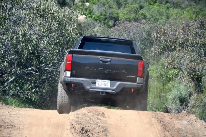2024 Toyota Tacoma Hybrid i-Force-Max rear driving over dirt road