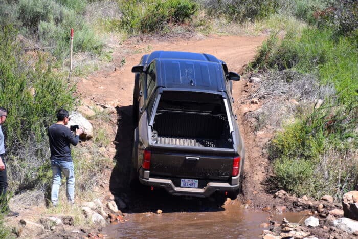 2024 Toyota Tacoma Hybrid i-Force-Max Trailhunter driving up steep hill