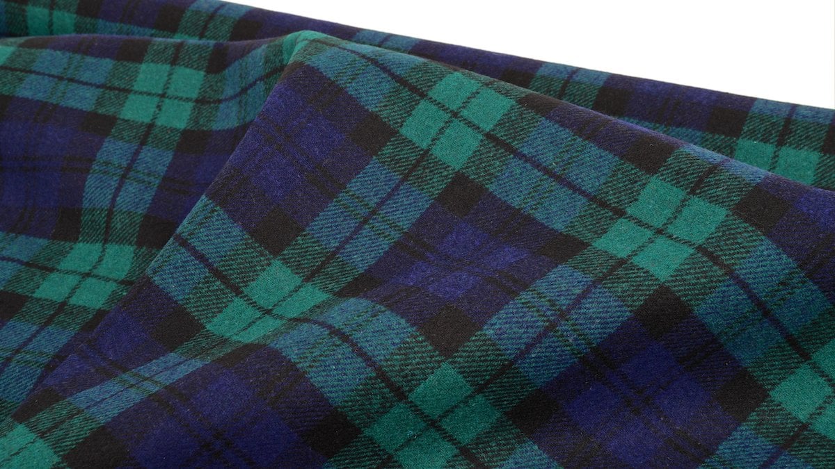 Close-up of stylish green and navy plaid fabric, perfect for clothing and home decor.