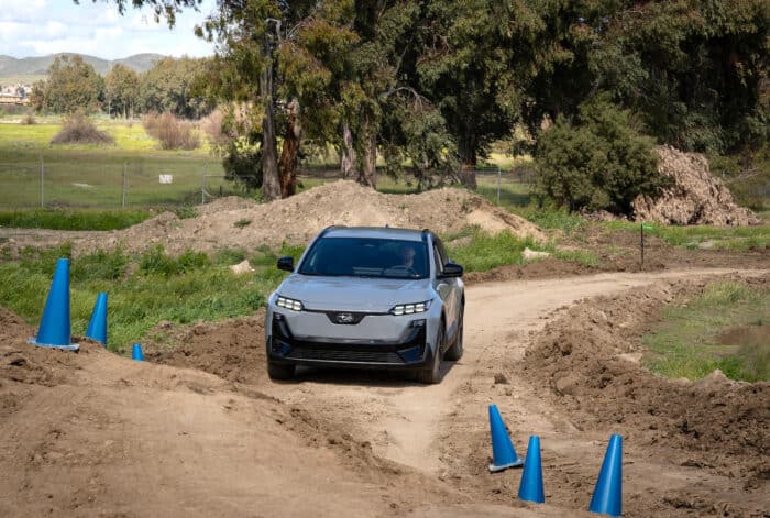 2026 Subaru Uncharted EV SUV front wide shot off roading on close circuit dirt road