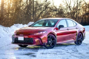 Red 2026 Toyota Camry SE Nightshade front view sitting in the snow